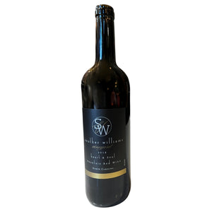 A dark glass wine bottle labeled “Souther Williams ‘Heart and Soul’ 2018” from WINE: SOUTHER WILLIAMS, featuring a black and gold label, crafted in the Blue Ridge Mountains and reflecting the unique character of North Carolina red wine.