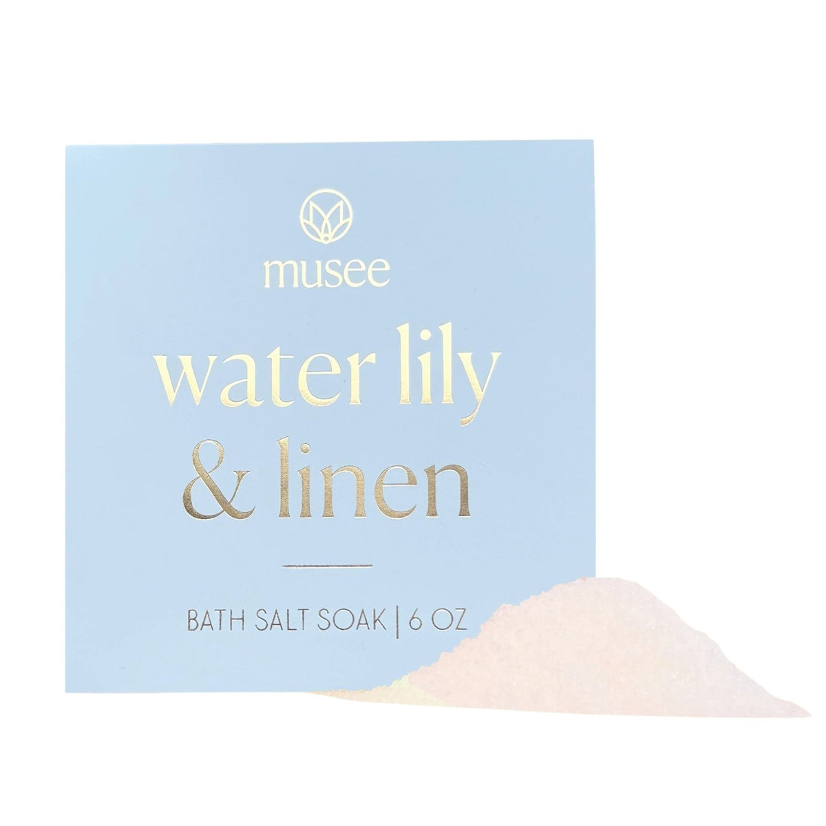 A blue box labeled “MUSEE - WATER LILY & LINEN MINI BATH SALT SOAK” by MUSEE sits neatly, with a small heap of bath salts—a calming blend of natural ingredients—spilled in front, inviting relaxation.