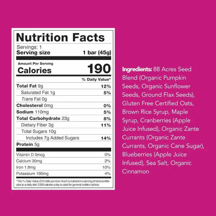 An 88 ACRES - TRIPPLE BERRY CRUMBLE Seed + Oat Bar rests on a light wooden surface, with its package partially open to show a portion of the nut-free and vegan granola bar inside. The packaging is white, featuring a vibrant purple section that displays the product name and various icons.