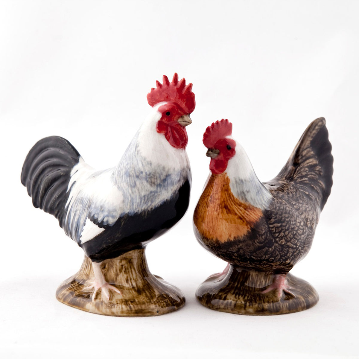 The QUAIL CERAMICS - DORKING SALT AND PEPPER SET by QUAIL DESIGNS features handpainted rooster and Dorking hen stoneware shakers, with the rooster in black, white, red and the hen in brown, black, red on a white background.