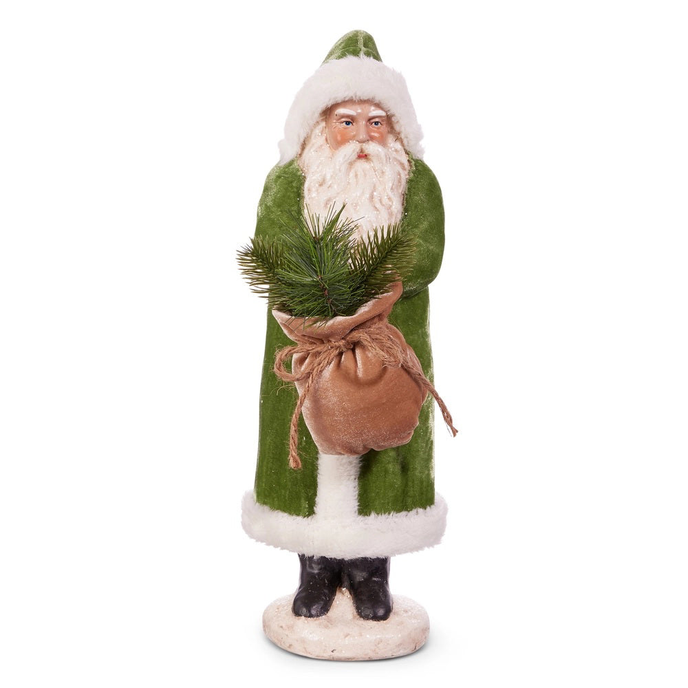 The RAZ IMPORTS OLD WORLD GREEN VELVET SANTA 17.25&quot; features Santa in a green coat and hat with white trim, holding a burlap sack of evergreens, standing on a round eco-friendly paper pulp base.