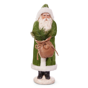 The RAZ IMPORTS OLD WORLD GREEN VELVET SANTA 17.25" features Santa in a green coat and hat with white trim, holding a burlap sack of evergreens, standing on a round eco-friendly paper pulp base.