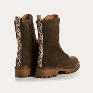 The REQINS Dusky Suede Ankle Boots in Khaki feature olive green suede leather, a chunky brown cleated heel, visible stitching, a pull tab at the back, and a rugged tread. A side zipper allows for easy wear.