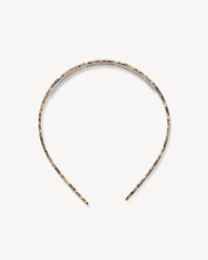 The MACHETE Ultralight Thin Headband in Monet, featuring a multicolored marbled pattern, rests on a plain light background.