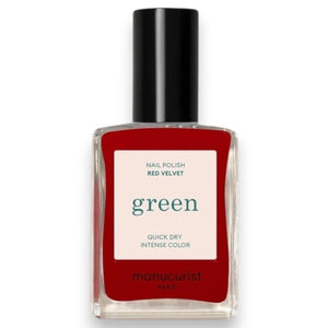 A hand with neatly manicured nails painted in MANUCURIST - GREEN™ NAIL POLISH IN RED VELVET by MANUCURIST INC rests on a textured red leather surface, creating a coordinated and stylish look.