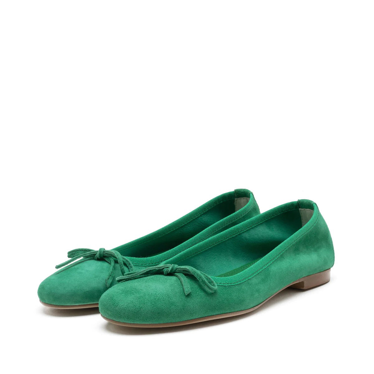 A pair of MICHELE LOPRIORE - MIA BALLET FLAT shoes by MICHELE LOPRIORE, featuring glittery silver leather with small bows on the front, displayed against a plain white background. Made in Italy, these shoes boast a low heel and a sleek, shiny texture.