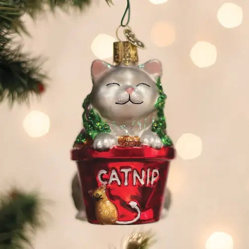 An OLD WORLD CHRISTMAS CATNIP CAT ORNAMENT shaped like a mellow white cat sitting in a red flower pot labeled “CATNIP” with a small cat icon on the front.
