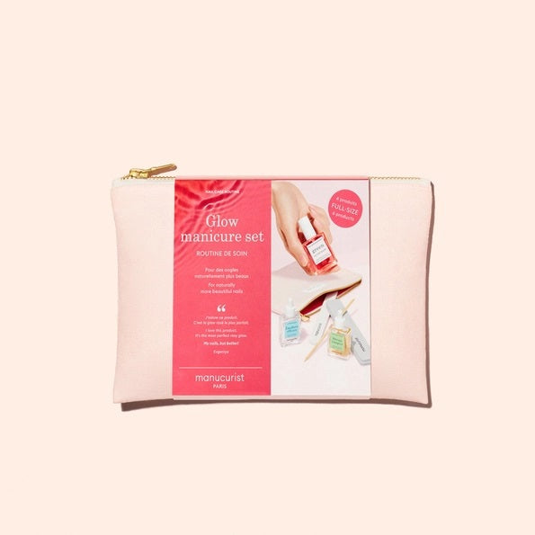 The MANUCURIST - GLOW MANICURE SET by MANUCURIST INC features a pastel pink zippered pouch, two nail files, and three bottles of vegan nail polish, all elegantly displayed on a light beige background.