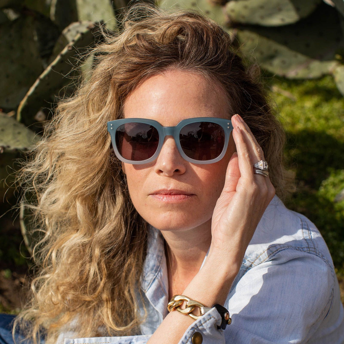 The CADDIS Jockamo Polarized Sunglasses feature a blue-green rectangular design with dark polarized lenses. The premium acetate frame is accented by white-tipped arms, and the brand "Caddis" is prominently displayed on both the lens and arm. These sunglasses combine a vintage aesthetic with a modern, sleek design perfect for casual wear.