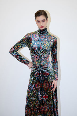 The FRANCO FERRARI RANAT Velvet Midi Dress features long sleeves, a high neck, a gathered front, and an intricate red, green, and blue floral pattern on a dark background.