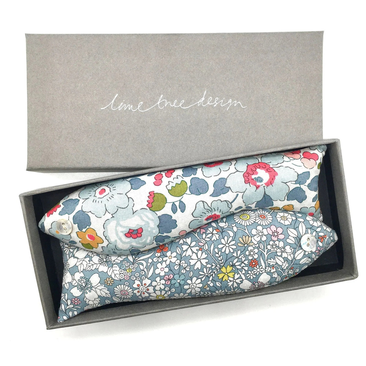 A gray rectangular box labeled &quot;LIME TREE COLLECTION LTD&quot; contains a LAVENDER FISH - LADY JANE GRAY SACHET crafted from Liberty Tana Lawn fabrics featuring different floral designs in pastel colors with touches of red, yellow, and green. The interior of the box is black.