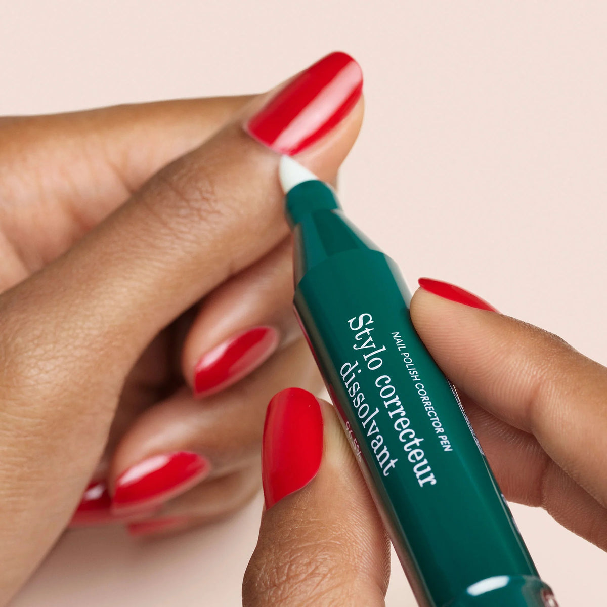 The MANICURIST - CORRECTOR PEN by MANUCURIST INC is a green and pink pen with a clear cap and white brush tip labeled “Stylo correcteur,” ideal for fixing nail polish or gel errors. Shown lying on a white background.