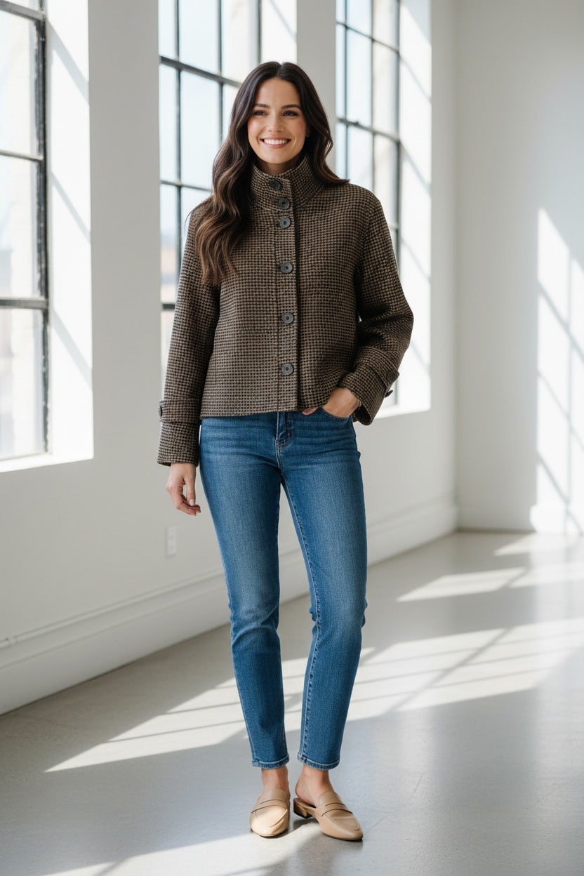 A woman with straight, light brown hair is seen from behind wearing the KINROSS KINROSS CASHMERE HOUNDSTOOTH BUTTON MOCK COAT and blue jeans against a plain white background.