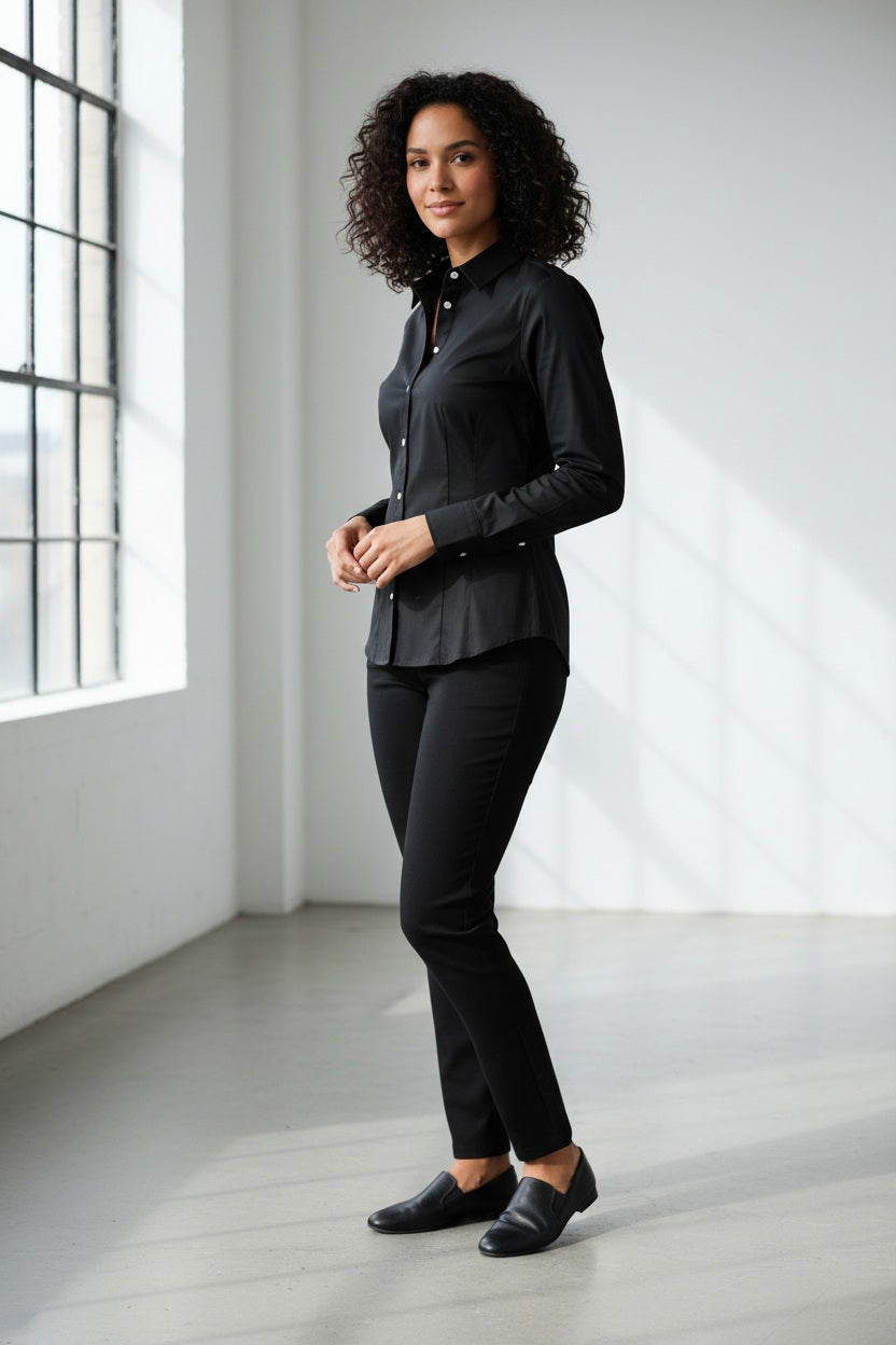 A person with blond hair in a bun is wearing the HINSON WU - JAMIE LONG SLEEVE “T” SHIRT IN BLACK, standing against a plain white background. Looking at the camera with a relaxed posture, the individual showcases an ensemble by HINSON WU that exudes refined style while ensuring comfort.