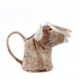 The QUAIL CERAMICS - GOAT JUG MEDIUM by QUAIL DESIGNS is a handpainted stoneware mug shaped like a goat’s head with detailed brown and white fur, upright ears, and a neck-shaped handle inspired by the British Toggenburg Goat jug.