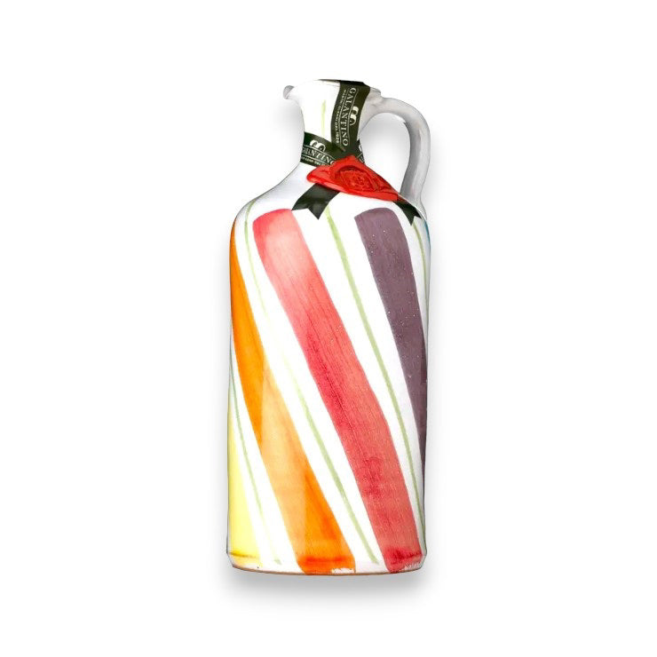 The GALANTINO - RAINBOW WAVES EXTRA VIRGIN OLIVE OIL from ZIA PIA IMPORTS is a decorative ceramic bottle from Puglia, Italy. It features a colorful design with vertical stripes in red, orange, yellow, purple, and white. This hand-painted bottle includes a handle, a sealed spout with wax-like material, and a label around the neck—perfect for storing extra virgin olive oil.