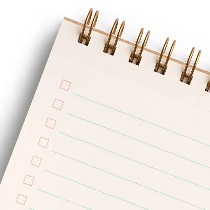 A close-up of the E. FRANCES - TASK PAD BEE by E. FRANCES PAPER shows a spiral-bound notebook with checkboxes on the left and light blue ruled lines, mostly blank, against a white background.