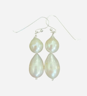The ANN LIGHTFOOT - DOUBLE DROPLET FRESHWATER PEARL EARRINGS feature teardrop-shaped white pearls on sterling silver hooks, shown against a plain white background.