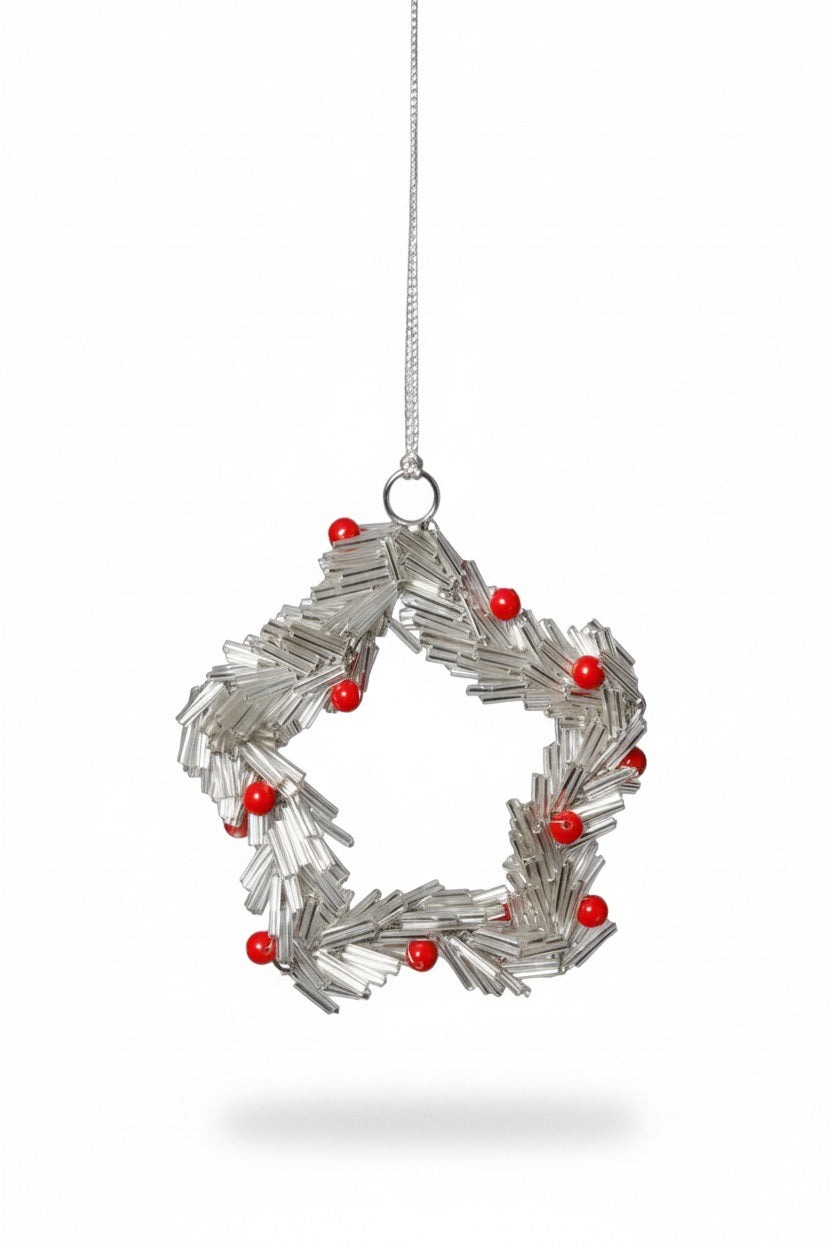 Two BEADED STAR ORNAMENT SILVER WITH RED BERRIES 4″ ornaments made of silver tubes and red beads, displayed on an iron glass coaster and hanging from white ribbons.