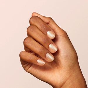 A clear glass bottle of gold glitter nail polish with a black cap, labeled: “MANUCURIST - GREEN™ NAIL POLISH IN GOLD, MANUCURIST INC, Quick Dry Intense Color.” This bio-sourced nail polish delivers vibrant color and shine while being gentle on your nails.
