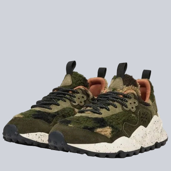 The FLOWER MOUNTAIN - KOKETSU SNEAKER by FLOWER MOUNTAIN/FALC USA features an olive-green teddy bear effect fabric upper, complemented by black laces on a white, speckled, ultra-lightweight rubber sole. The shoe includes a convenient loop at the heel, a distinctive flower-shaped accent near the laces, and is equipped with a rugged black outsole designed for optimal traction.