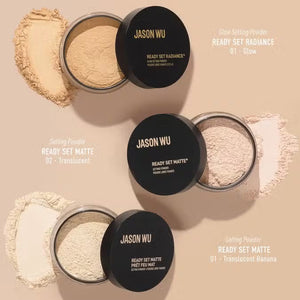 A small round container of JASON WU BEAUTY - READY SET MATTE 2 translucent setting powder is placed on a light brown, geometric background. The container features a black lid with white text displaying the product name, promising a flawless matte finish.