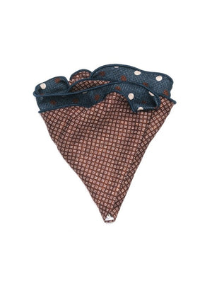 The EDWARD ARMAH - SILK REVERSIBLE POCKET CIRCLE NAVY DOTS by EDWARD ARMAH features a blue triangular design with white and brown polka dots, a patterned brown edge, and denim-like accents, shown on a white background.