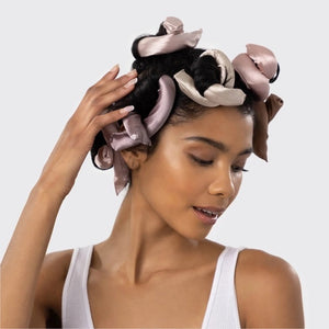 Six satin-wrapped flexi rods from KITSCH are displayed on a light background in brown and pink, with some coiled and others straight—ideal for achieving effortless, heatless curls using this vegan hair roller set.