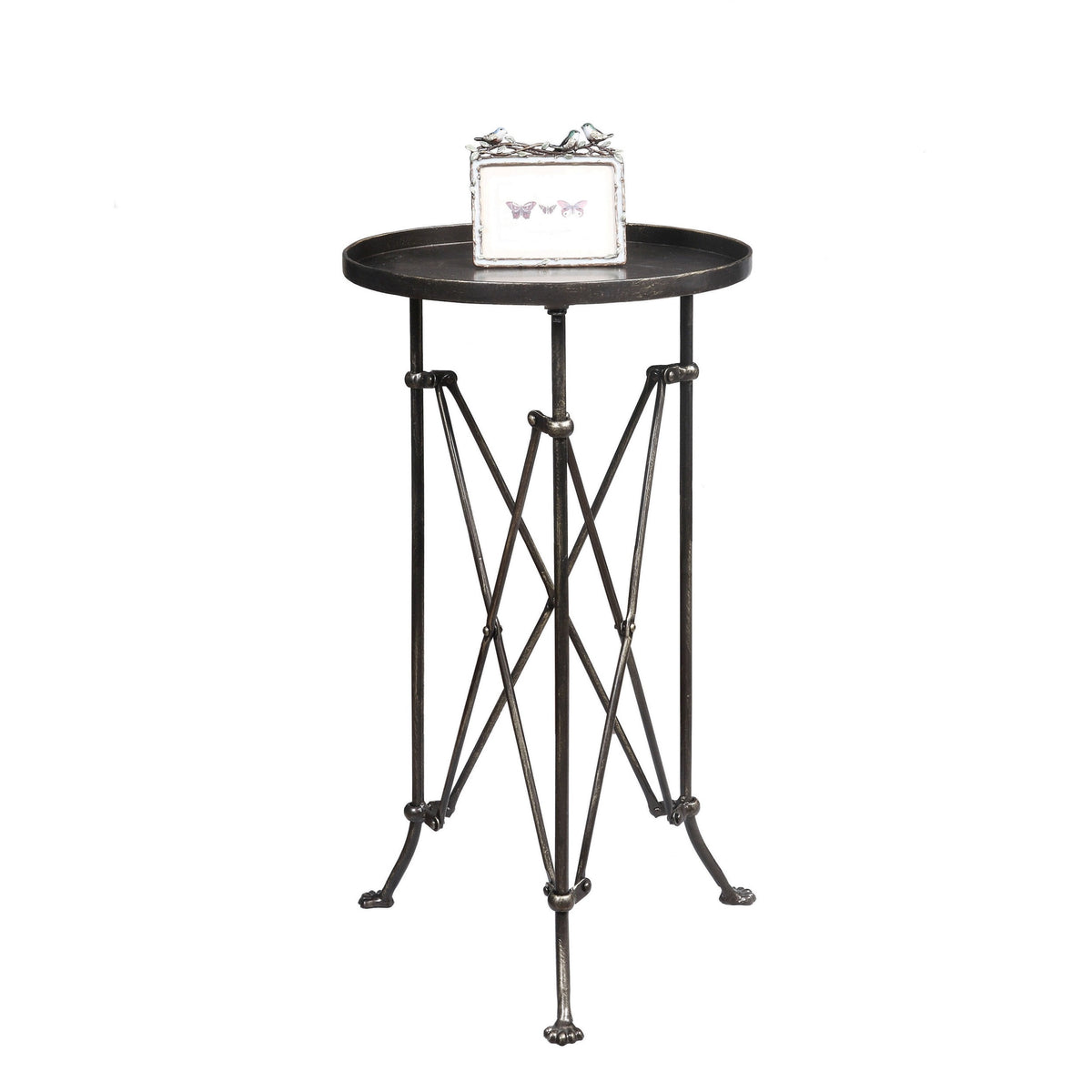 The CREATIVE COOP BRONZE FINISH METAL ACCENT TABLE is a small, round metal side table with a dark bronze finish, raised edge, geometric crisscross legs, and three vintage claw feet.