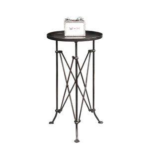 The CREATIVE COOP BRONZE FINISH METAL ACCENT TABLE is a small, round metal side table with a dark bronze finish, raised edge, geometric crisscross legs, and three vintage claw feet.