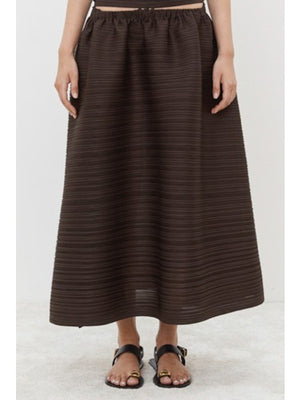 Close-up of MEIMEIJ - PLISSE SKIRT by MEIMEIJ, featuring a textured black fabric with an architectural fine weave pattern.