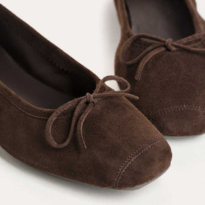 The REQINS Harmony suede ballerina flats in marron feature a rounded square toe and a small decorative bow on the front of each shoe.