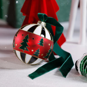ZODAX TREE DESIGN GLASS BALL ORNAMENT: A 4-inch glass spherical ornament featuring a red band with green pine tree patterns, alternating with black and white stripes, finished with a dark green velvet ribbon.