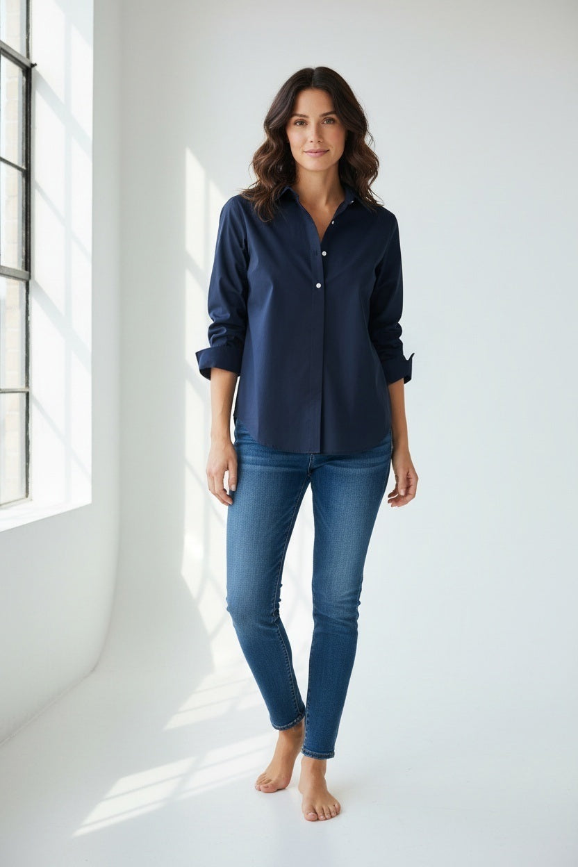 A person wearing the HINSON WU - ZOEY SHIRT in black, with the sleeves rolled up and paired with blue jeans. The image highlights the classic tailored design from shoulders down against a plain white background.