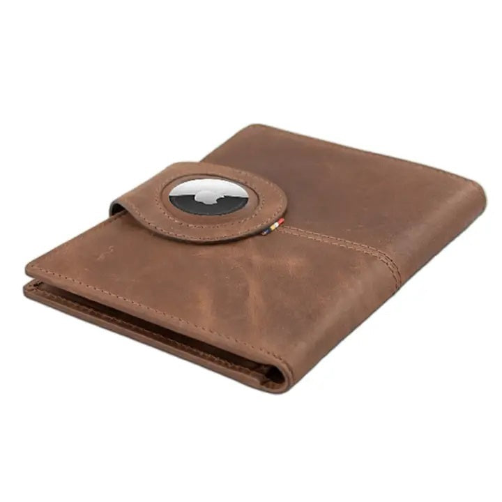 GARZINI RFID-blocking leather passport holder with AirTag compartment in brown, featuring a strap and snap button closure on a white background. The holder has a slightly worn, vintage look.