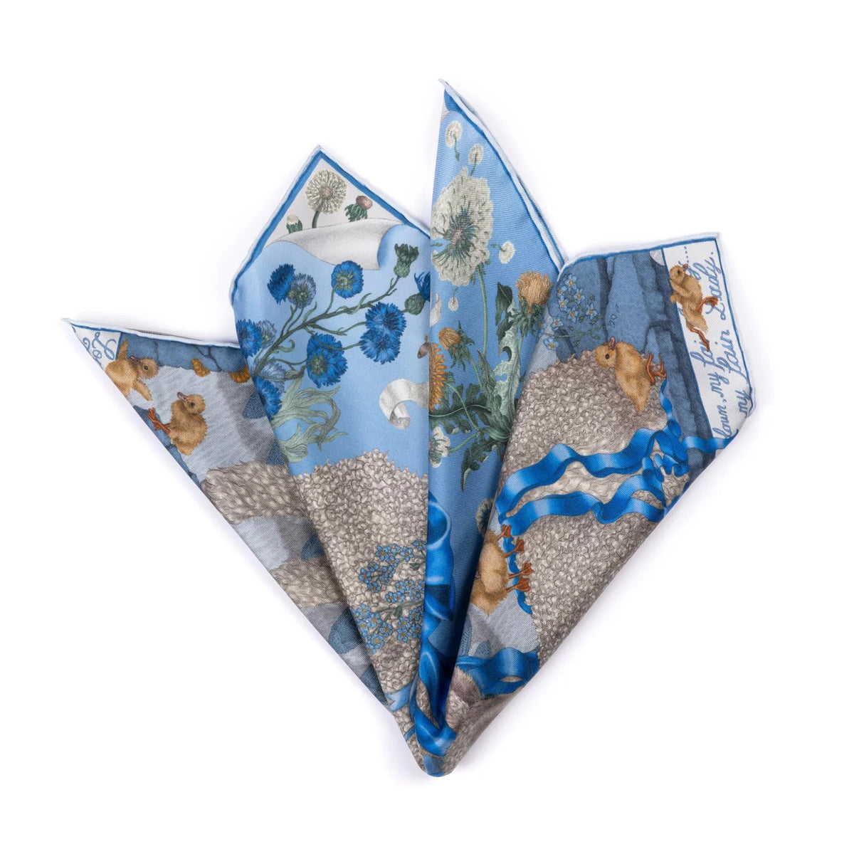 The SABINA SAVAGE - LONDON BRIDGE IS FALLING DOWN SILK TWILL SCARF 42CM POWDER/FROST from SABINA SAVAGE ENGLAND is artfully folded into a floral shape, showcasing a blue and white pattern with flowers, baby lambs, and intricate details bordered by a bold blue.