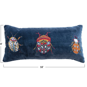 The CREATIVE COOP BLUE VELVET LUMBAR PILLOW features embroidered designs of three colorful beetles in various patterns across the front.