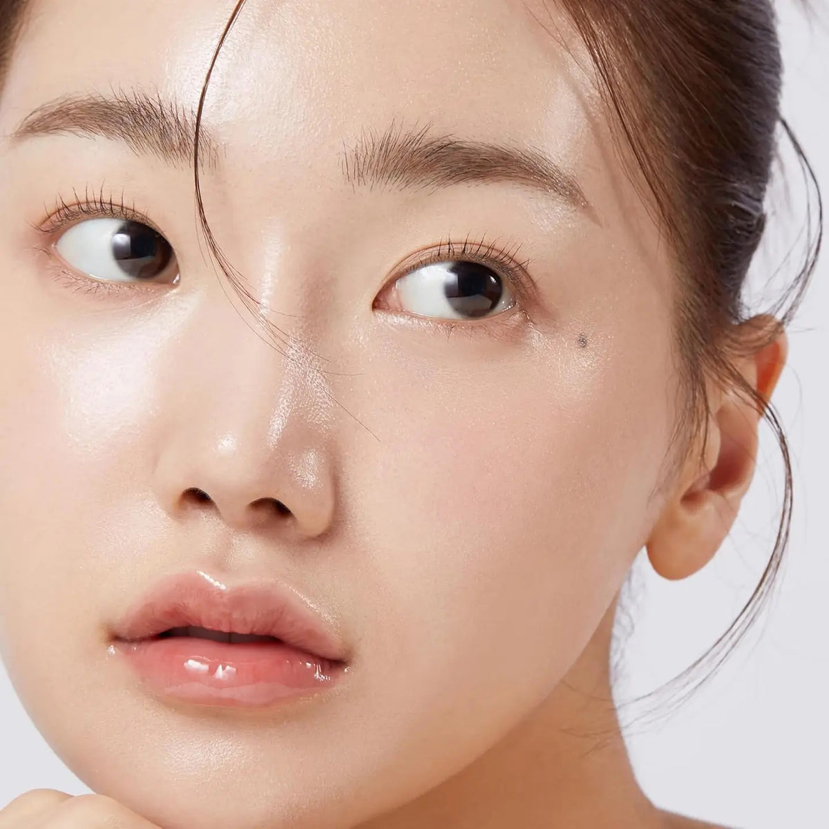 A pink MEDICUBE Triple Collagen Serum bottle on a peach background promises a glass glow. It highlights Hydrolyzed Collagen for moisture, Atelo Collagen for reducing wrinkles, and Soluble Collagen for enhanced skin elasticity and firmness. Brand: Asian Beauty Wholesale.