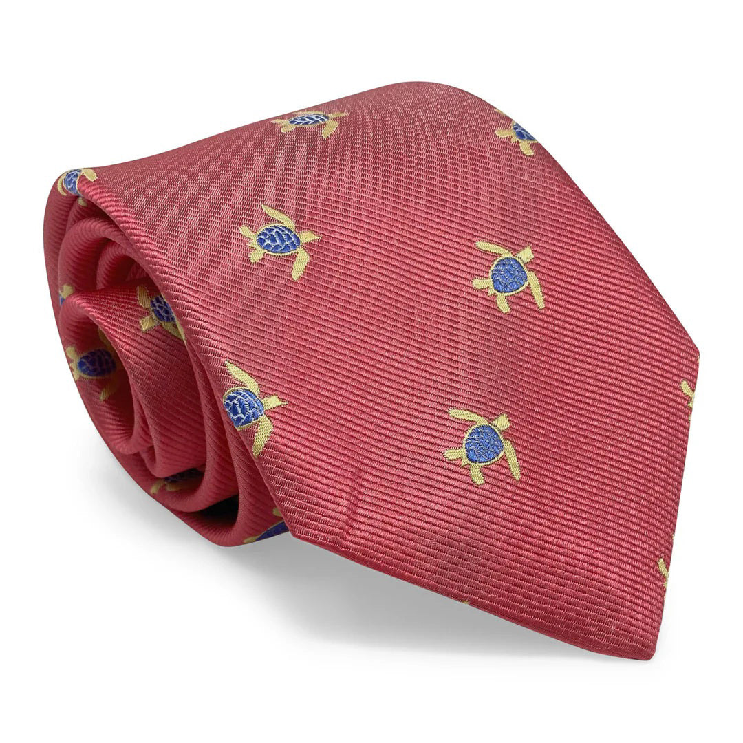 The PETER BLAIR - TURTLES TIE IN CORAL by BIRD DOG BAY features a repeating pattern of yellow and blue sea turtles on pink silk; handmade in New York.