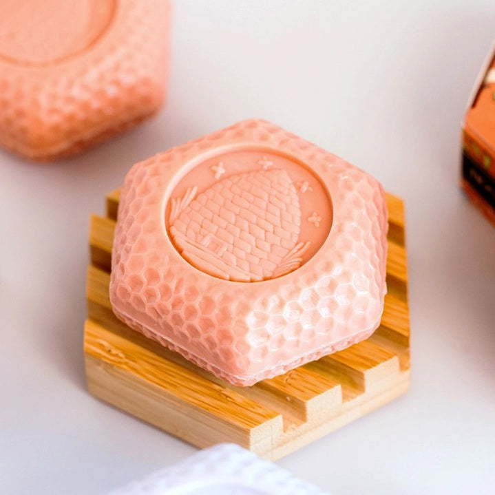 The BAUDELAIRE - BAMBOO HEX SOAP DISH is a hexagonal bamboo soap dish with horizontal grooves and the word “BAUDELAIRE” engraved on the front. Featuring a natural finish, this eco-friendly accessory brings both style and function to your bathroom sink or shower.