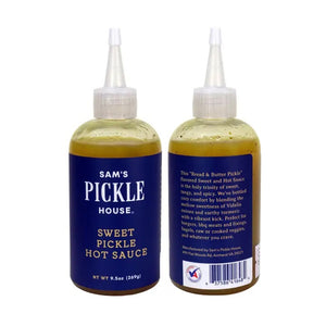 A squeeze bottle labeled “THE PICKLE HOUSE - SWEET PICKLE HOT SAUCE” features a dark blue label with white text. The bottle holds a greenish-yellow, sweet and hot sauce that’s ideal as a salad dressing and comes with a pointed nozzle cap.