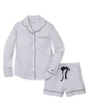 A neatly folded set of elegant pajamas from the FEARRINGTON LIFESTYLE COLLECTION featuring a classic French ticking design. The navy and white striped twill short set has a button-up front, a chest pocket adorned with a black sheep emblem, and a collar. The label "Petite Plume" is visible, and an attached tag displays the same brand name and logo.