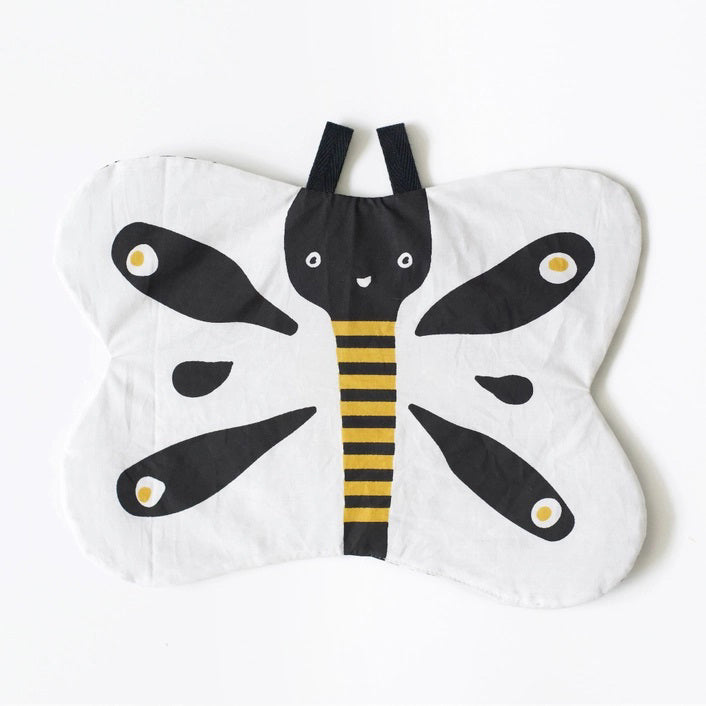 The WEE GALLERY - BUTTERFLY ORGANIC CRINKLE is a children's soft fabric toy, crafted from organic cotton. It features a butterfly shape with a smiling face in the center and a striped yellow and black body. The white wings are adorned with black patterns and yellow accents, providing visual stimulation. Additionally, it includes a small loop at the top for hanging.
