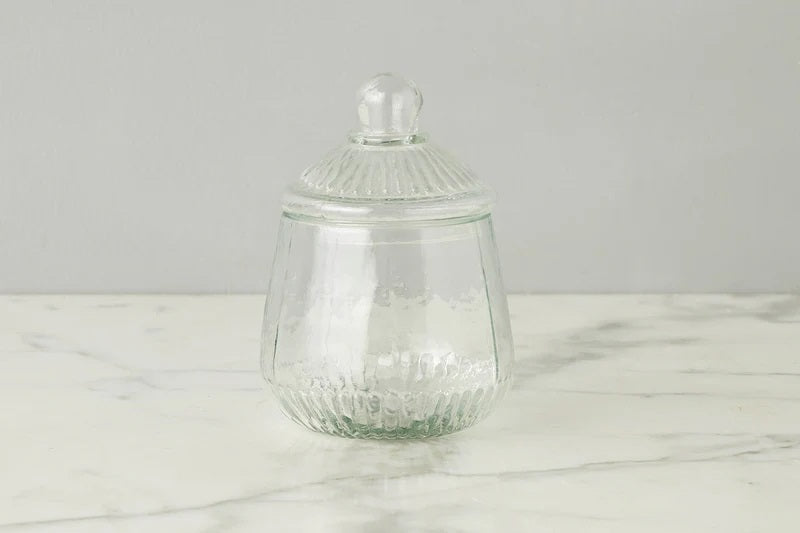 ETUHOME Bistro Glass Biscuit Jars with lids sit on a wooden tray, filled with snacks and orange-wrapped candies. The classic jar design by ETUHOME stands out against the softly blurred background.