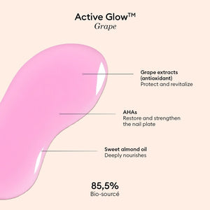 A pink serum drop labeled with its ingredients: raspberry extract (strengthens nails), AHAs (restore and harden), and sweet almond oil (nourishes). The text highlights that MANUCURIST - ACTIVE GLOW CARE POLISH by MANUCURIST INC is 85.5% plant-based—making it the ideal nail strengthener for achieving healthy, glass-like nails.