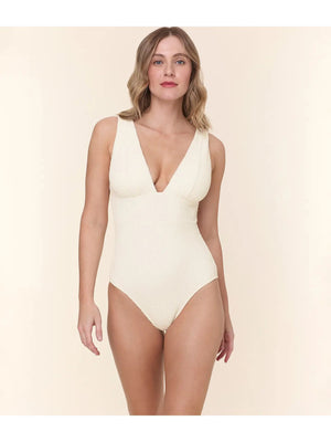 A woman models the ANDIE SWIM The Mykonos One Piece Swimsuit in Textured Wave Gardenia, standing against a plain light beige background.
