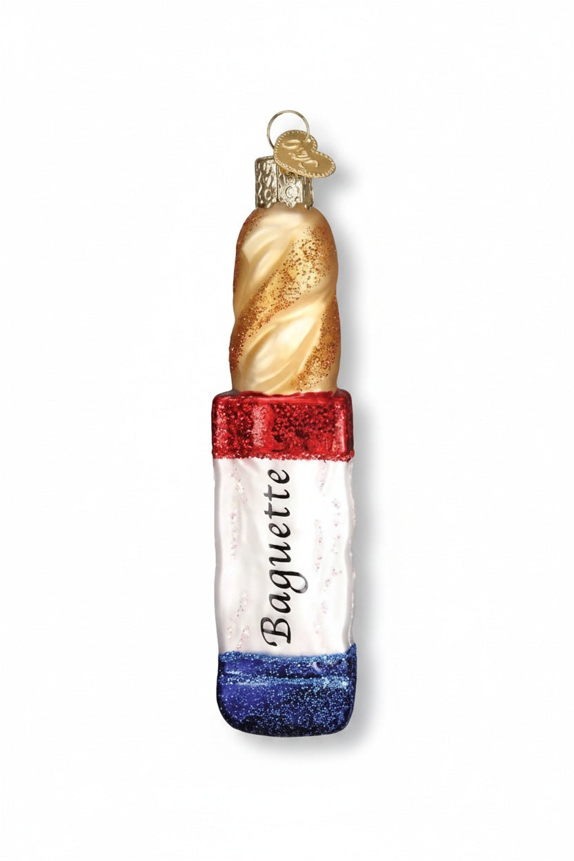 Old World Christmas BAGUETTE ORNAMENT shaped like a French bread baguette, featuring a gold spiral top and a red, white, and blue base labeled with the word “Baguette.”