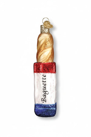 Old World Christmas BAGUETTE ORNAMENT shaped like a French bread baguette, featuring a gold spiral top and a red, white, and blue base labeled with the word “Baguette.”