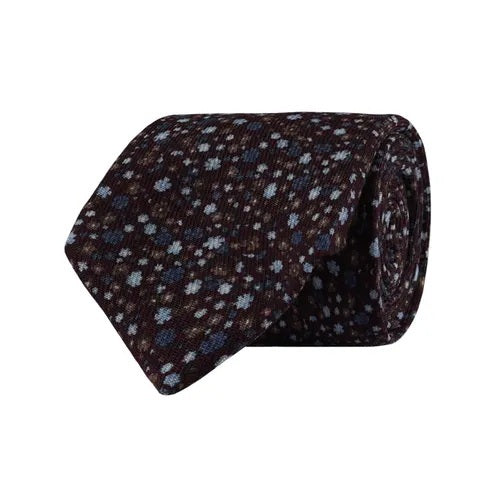 The AMANDA CHRISTENSEN - FLORAL WOOL TIE IN BORDEAUX MELANGE is a sophisticated tie in a rich bordeaux melange, detailed with small light blue and white floral-like dots. With its refined pattern and high-quality wool construction, this AMANDA CHRISTENSEN accessory is an essential addition to any men’s collection.