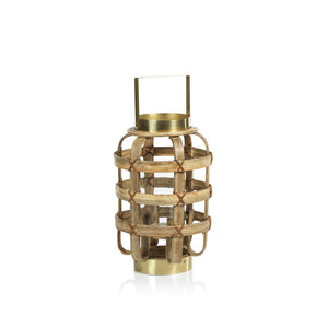 The ZODAX Bamboo Lantern with Brass Trim is a decorative lantern featuring a rustic design. It has a woven, cage-like structure made of bamboo slats held together with red twine. The lantern boasts a brass base, top, and handle, creating a harmonious blend of natural and metallic aesthetics. Dimensions: 20.32 cm x 20.32 cm x 33.02 cm (8 in x 8 in x 13 in).